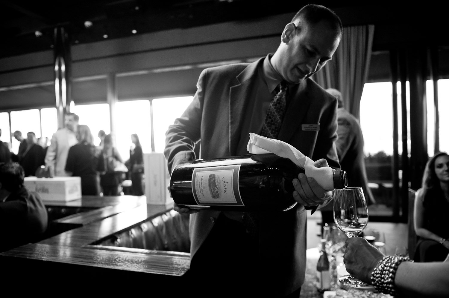 black and white photo of a man pouring a large format bottle of Jordan Winery Cabernet into a glass at a 40th Anniversary Rooftop Party Hosted at the PH-D Rooftop Lounge at Dream Downtown in Manhattan