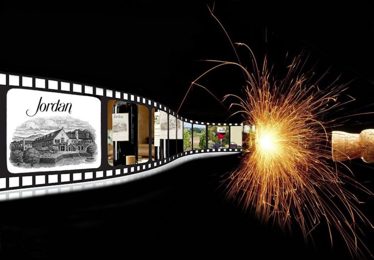 A piece of art from the 4 on 4 Jordan Winery art competition. It features a strip of film in the shape of a champagne bottle with sparks and a cork flying. In the frames are various pictures of Jordan Winery and red wine.