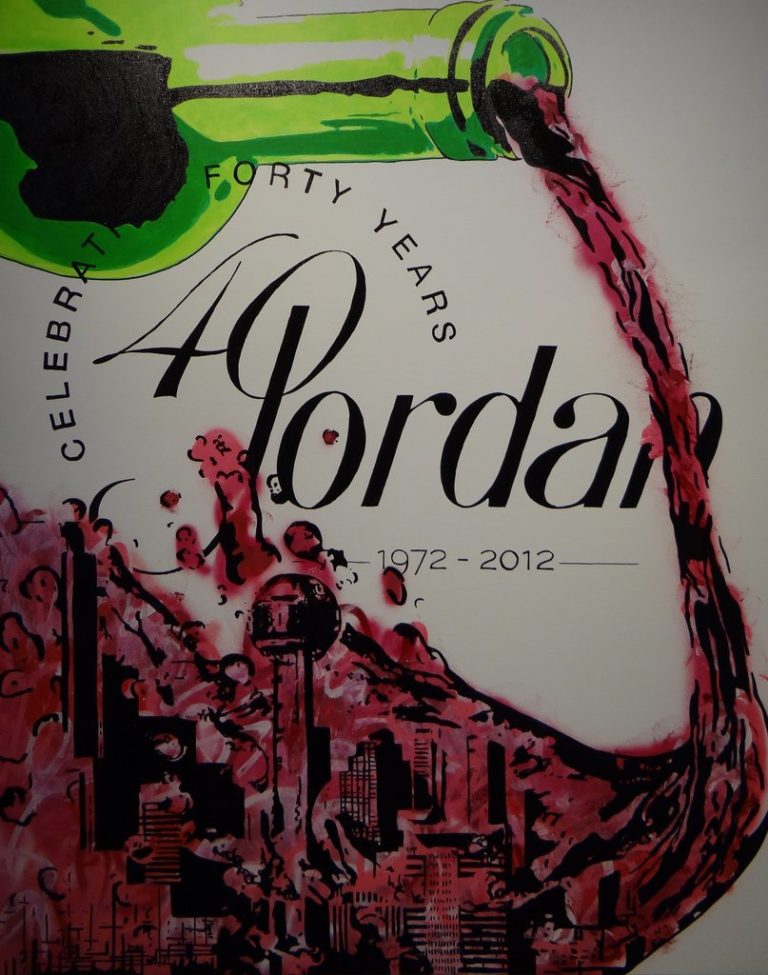 A piece of art from the 4 on 4 Jordan Winery art competition. It features the Jordan "Celebrating 40 Years" logo with a vibrant green bottle pouring red wine. The wine splashes to the left and in the shadows reveals a cityscape.