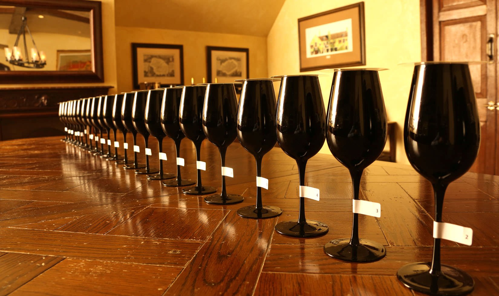 many blacked out wine glasses on a wooden table in the cellar room at Jordan Winery for a blind wine tasting