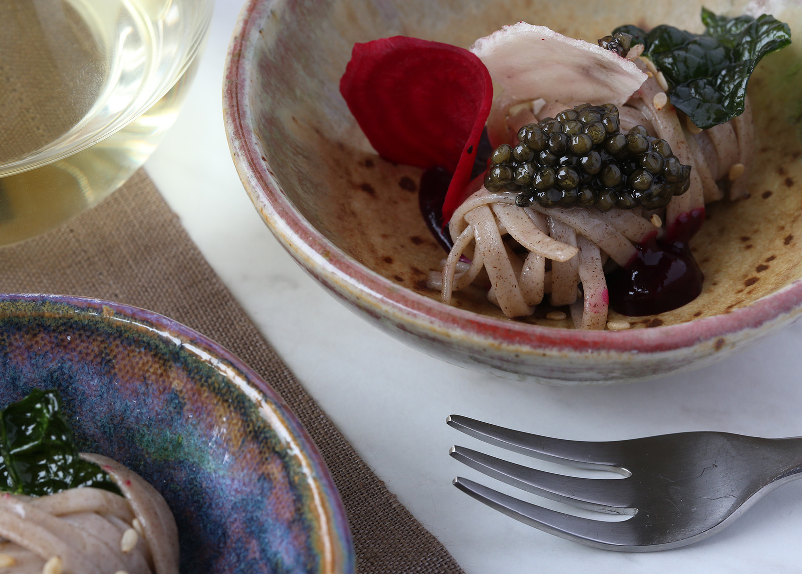 Soba noodles with caviar in a bowl at table setting