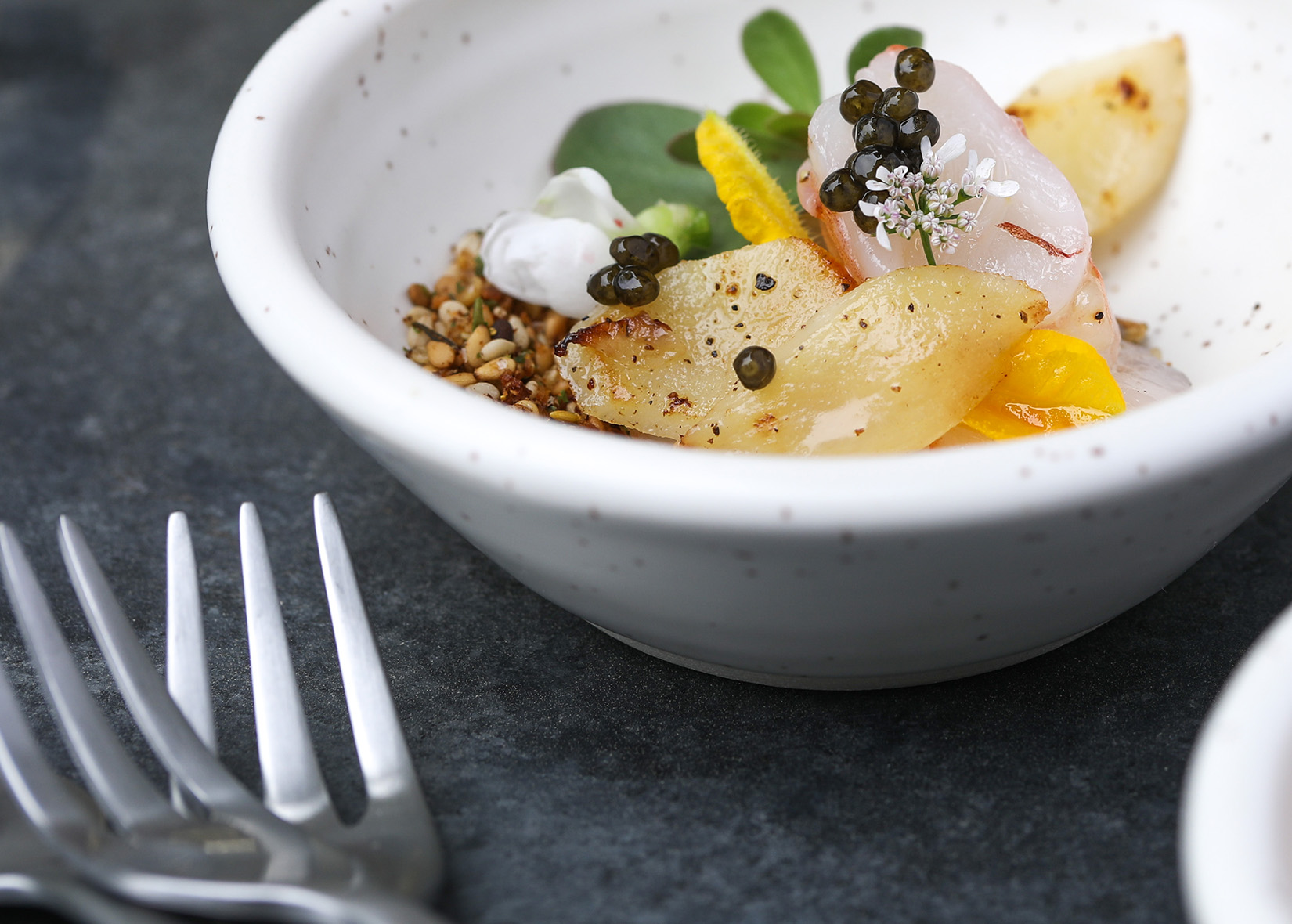 Olive oil poached prawns with Sonoma Sand recipe in white bowl next to forks