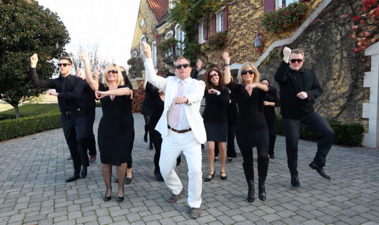 Still of John Jordan, CEO and proprietor of Jordan Winery performing Gangam Style dance with other Jordan Winery employees behind him in a video made by Jordan Winery