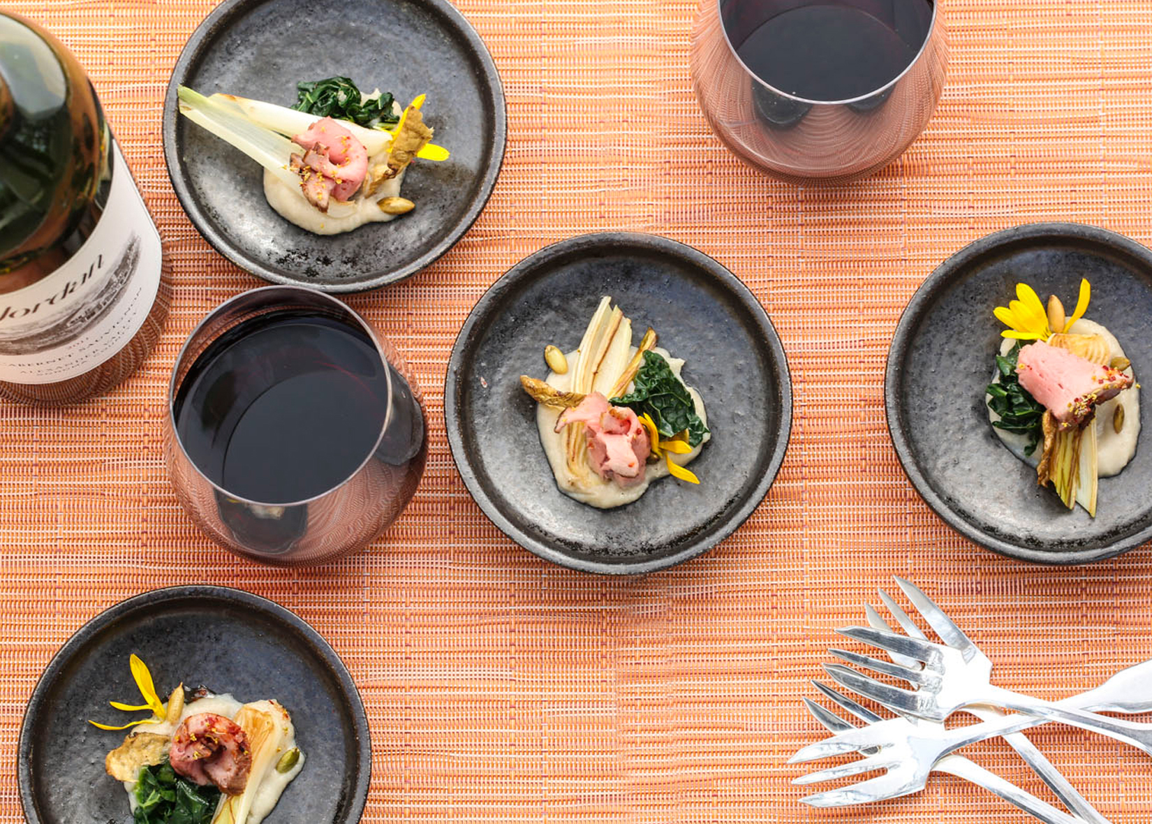 Pork tenderloin with spring onions on plates at table setting