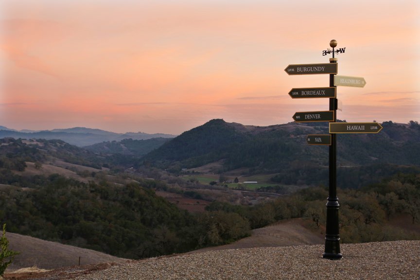 Sign post at Vista Point on Jordan Winery Estate with sunset in background