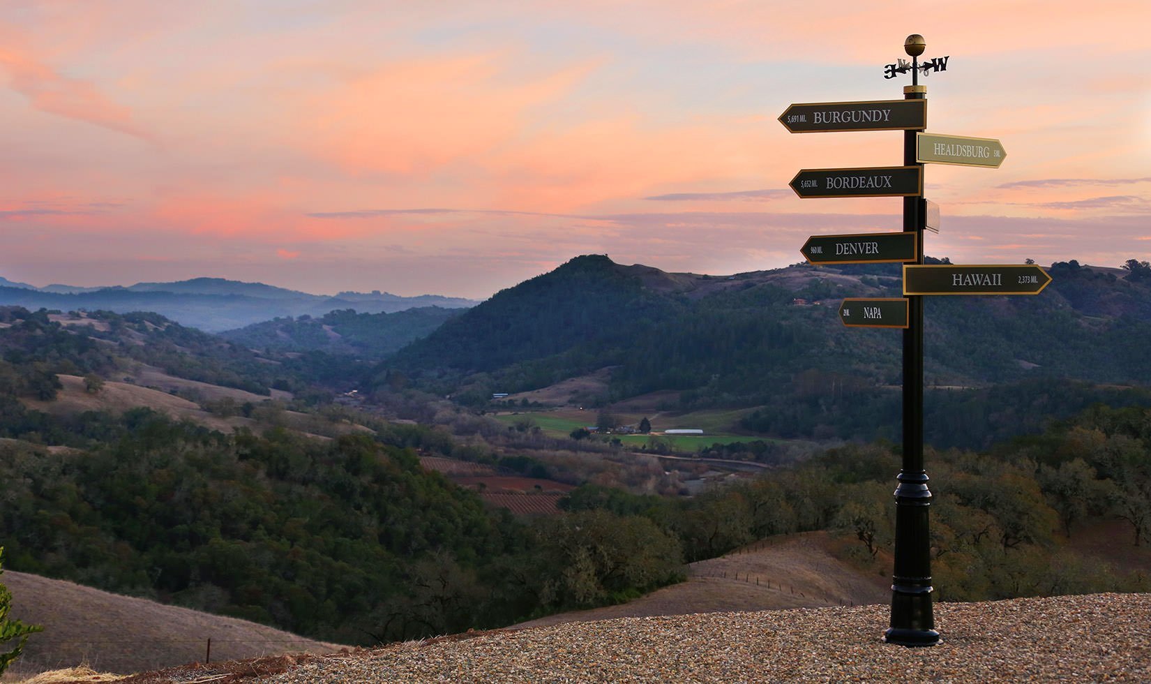 Sign post at Vista Point on Jordan Winery Estate with sunset in background