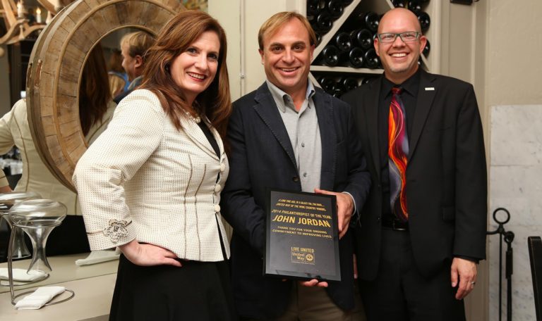 John Jordan, CEO and proprietor of Jordan Winery posing for a photograph holding his award for 2014 Philanthropist of the Year through United Way of Wine Country