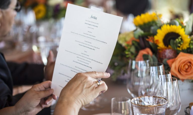 over the shoulder shot of someone holding the menu for the Jordan Winery 2015 Sunset Supper at Vista Point