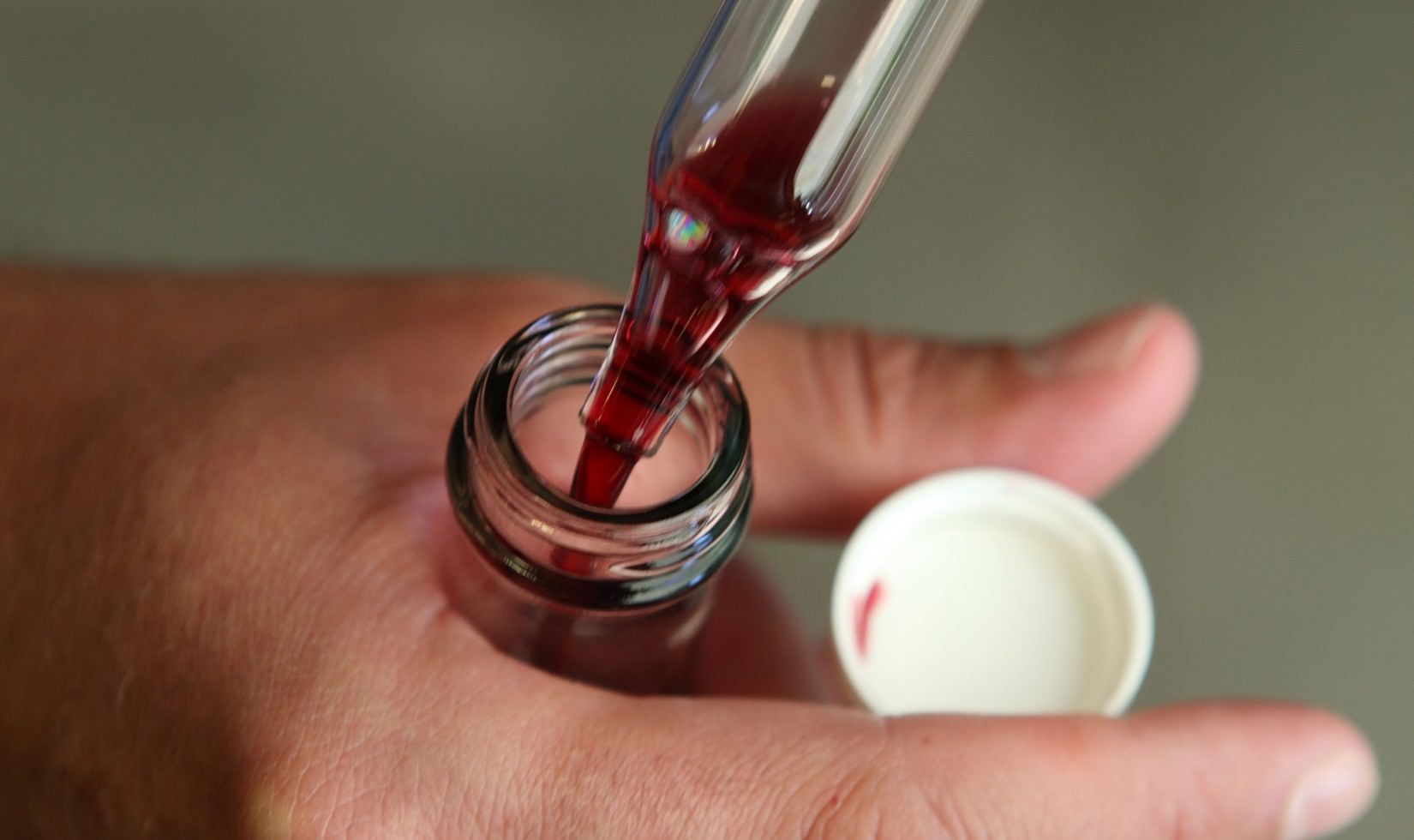 Close up of Cabernet juice sample being put into small sample bottle