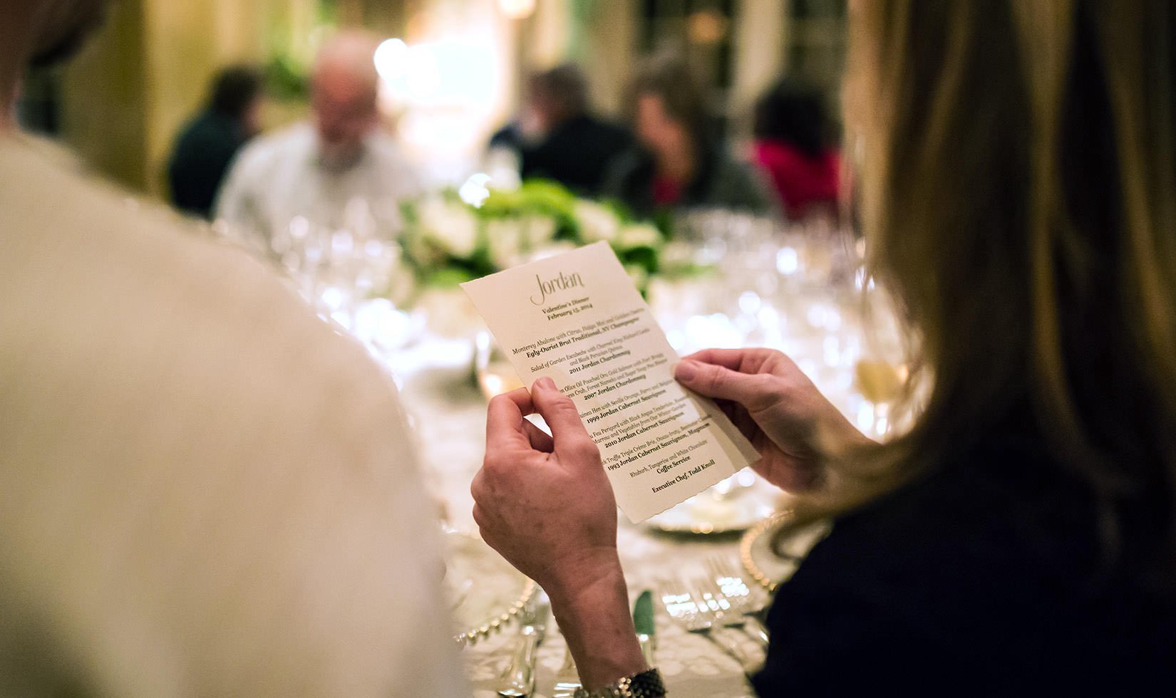 A guest holds the menu to read it.