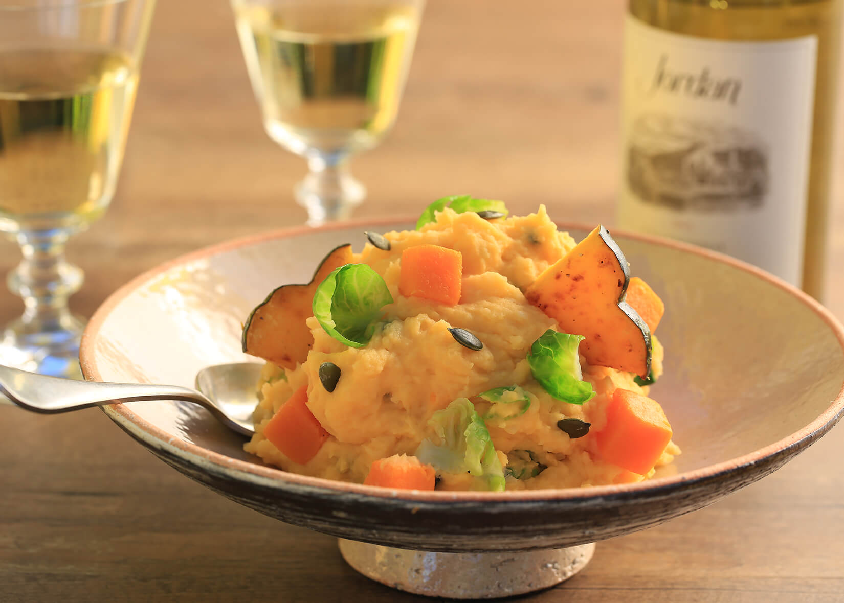 Butternut squash mashed potatoes in bowl next to Jordan Wine