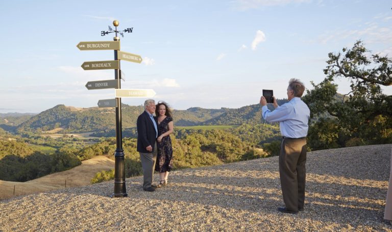 A couple poses next to the directional sign at Vista Point.