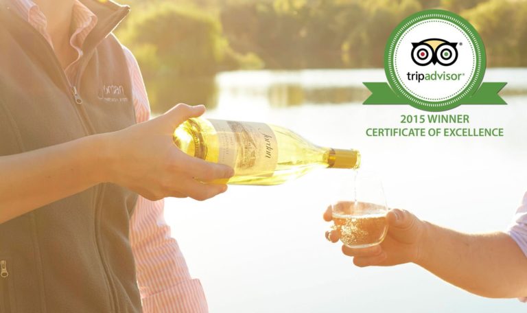 Jordan Winery Chardonnay being poured into a glass being held by someone with a lake in the background with Trip Advisor logo and image text: "2015 winner certificate of excellence"