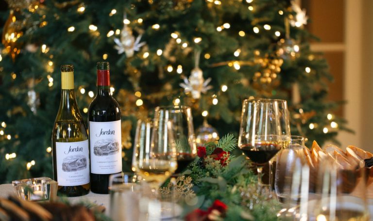 Holiday table setting in the Jordan Winery dining room with holiday tree in the background