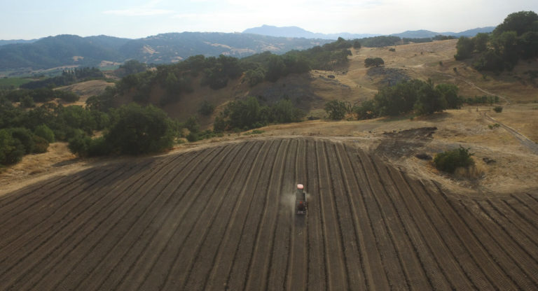 aerial view of a tractor in a bare field at Jordan Winery Estate as the process for replanting vines begins