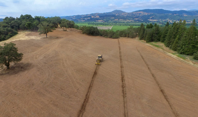aerial view of Tractor deep ripping vineyard soils for new Chateau Block at Jordan Winery