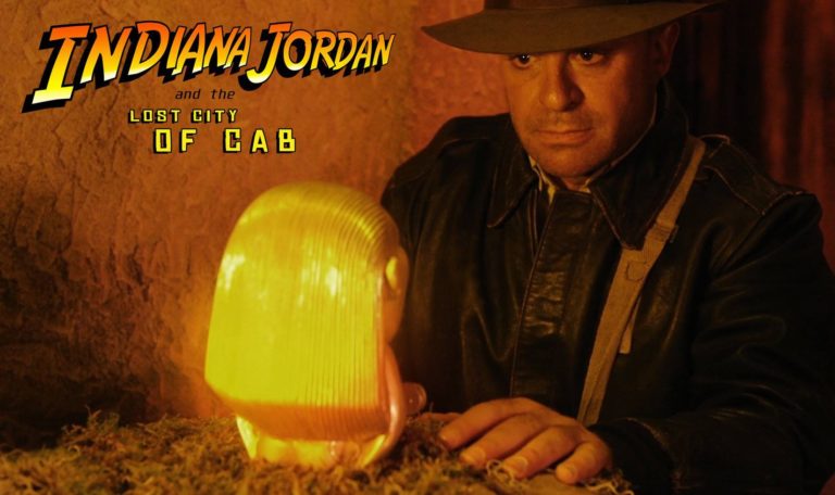 A still from a video made by Jordan Winery called "indiana jordan and the lost city of cab" featuring John Jordan dressed as Indiana Jones with image text "Indiana Jordan and the Lost City of Cab"