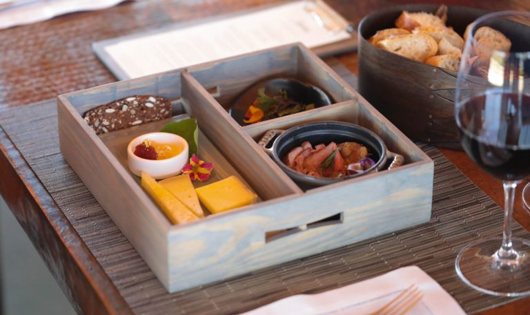 a Jordan Winery bento box with cheese and food bites at a table setting at Vista point at Jordan Winery