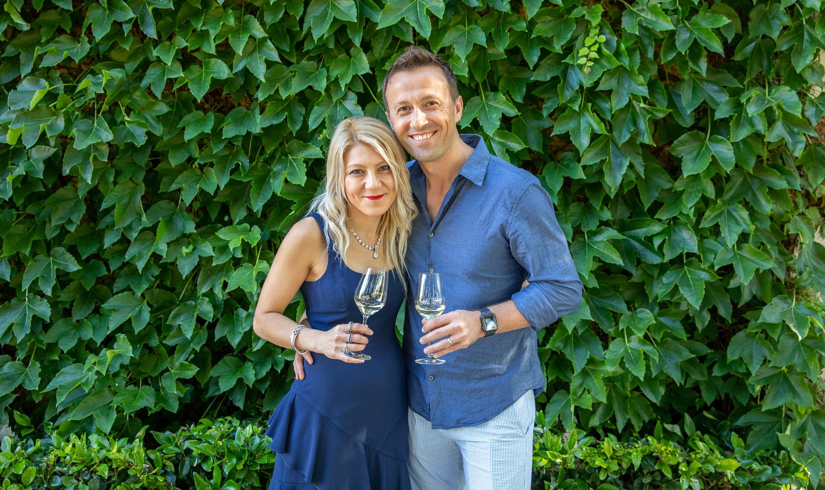 A couple in front of the ivy at Jordan Winery in wine country casual attire