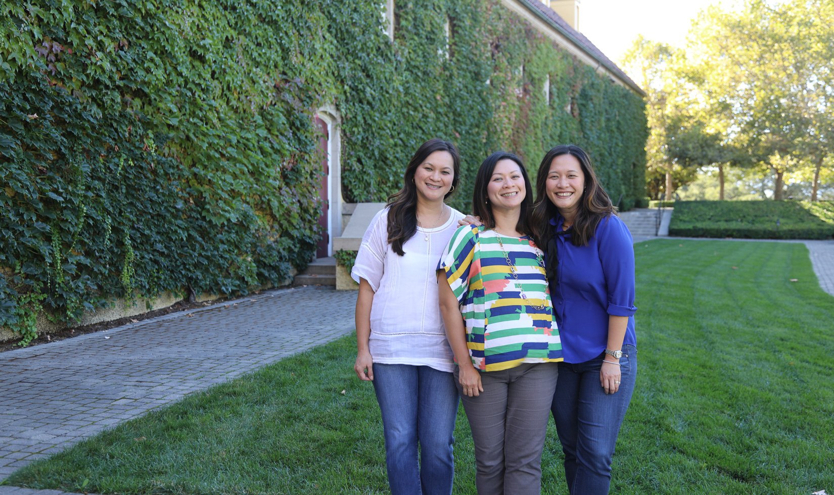 3 women at Jordan Winery in wine country casual attire. They're wearing nice jeans and blouses.