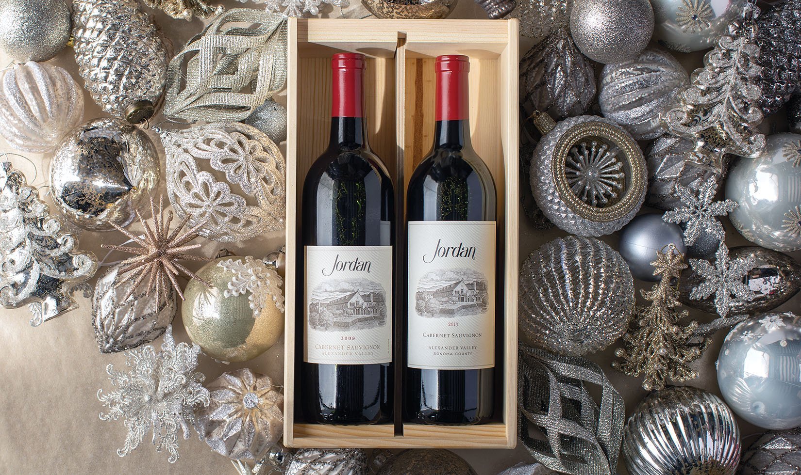 One bottle each of the 2008 and 2013 Jordan Cabernet Sauvignon in a wood box nestled around silver ornaments