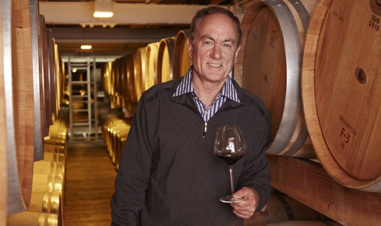 Rob Davis, former winemaker at Jordan Winery standing in the Jordan Winery cellar room with a poured glass of Jordan Cabernet