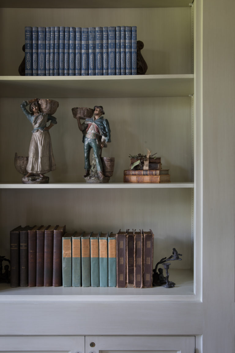 book shelf lined with books and figurines