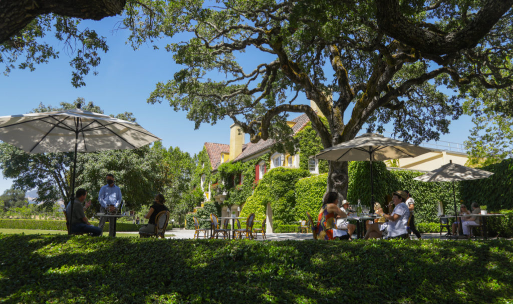 people sitting at bistro tables on outdoor terrace