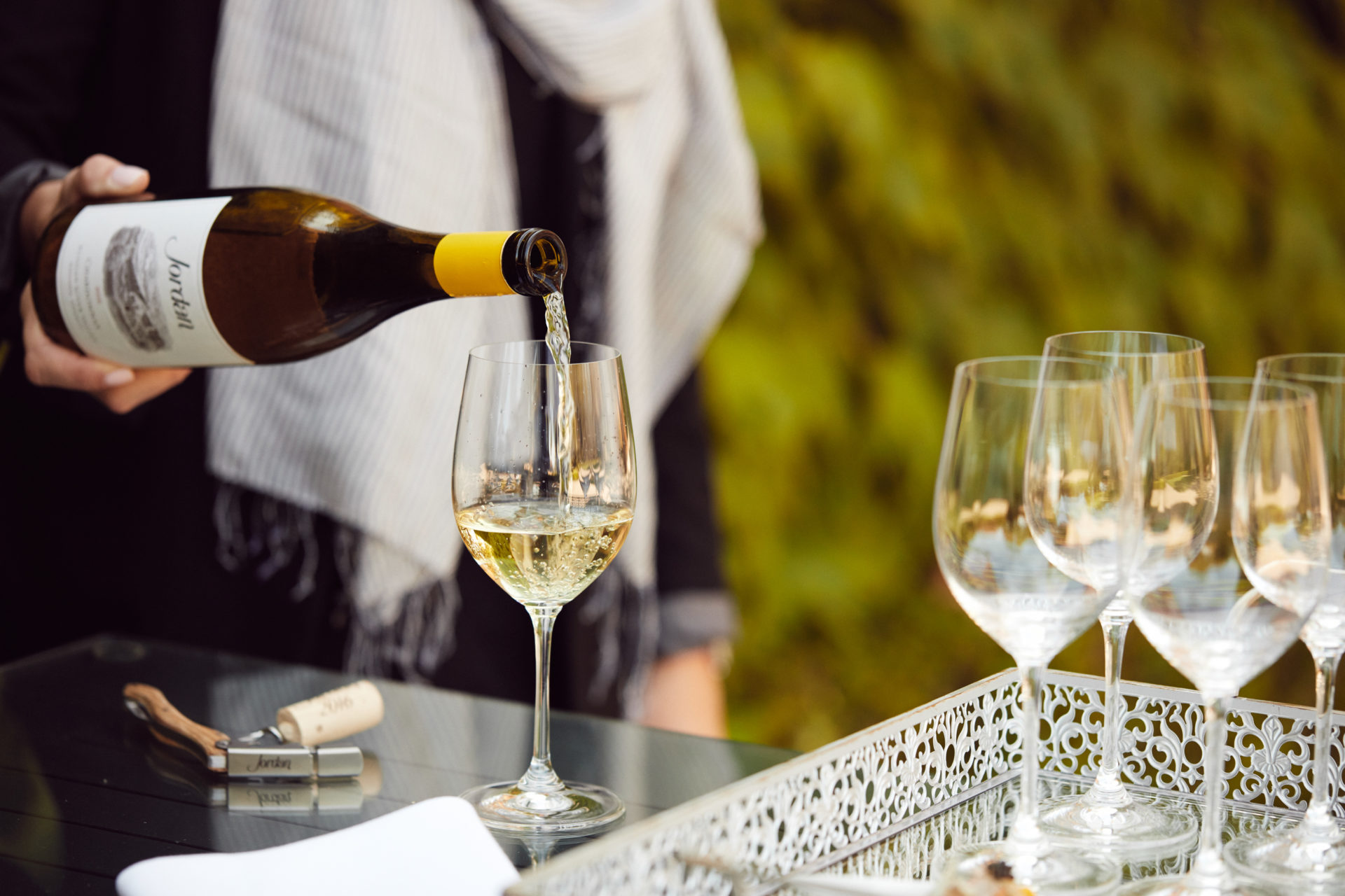 Hand pouring Jordan Chardonnay in outside setting