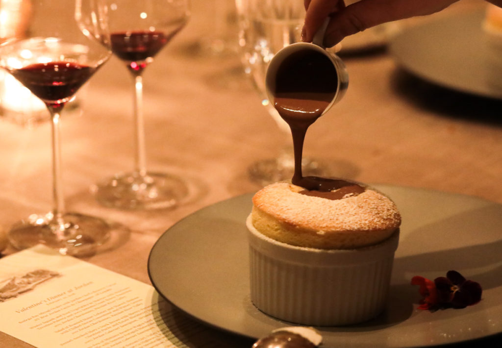 chocolate pouring on souffle at dinner table
