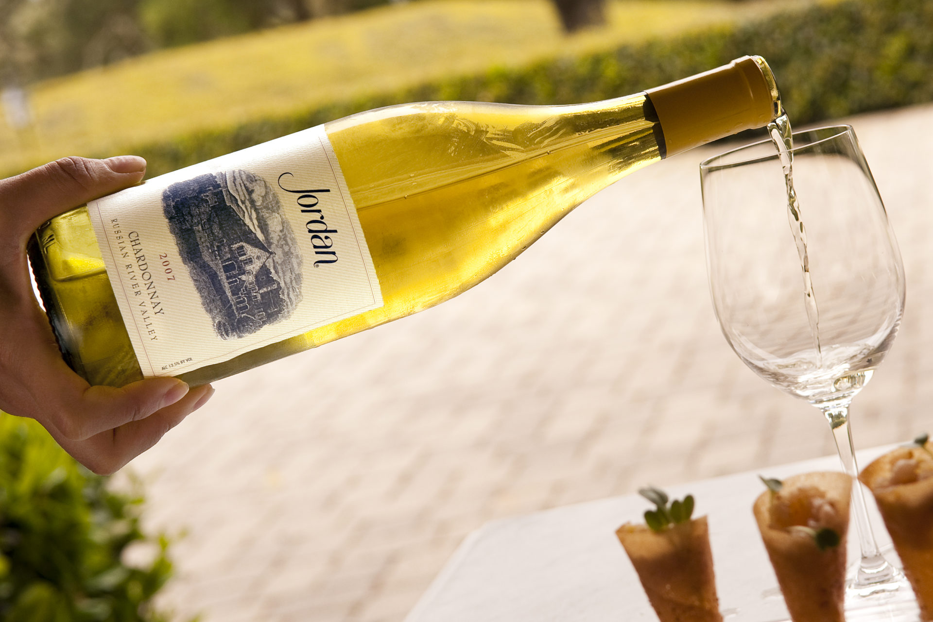 Jordan Chardonnay being poured into wine glass outside