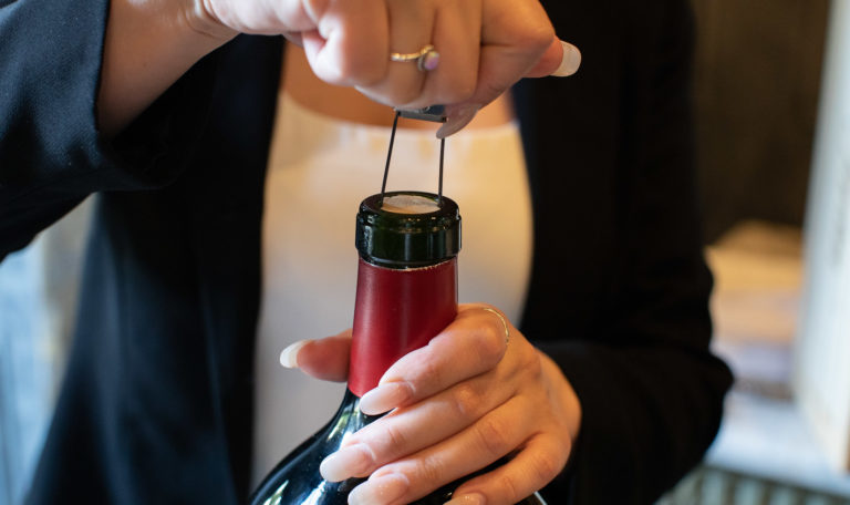 Person opening bottle of Jordan Cabernet Sauvignon