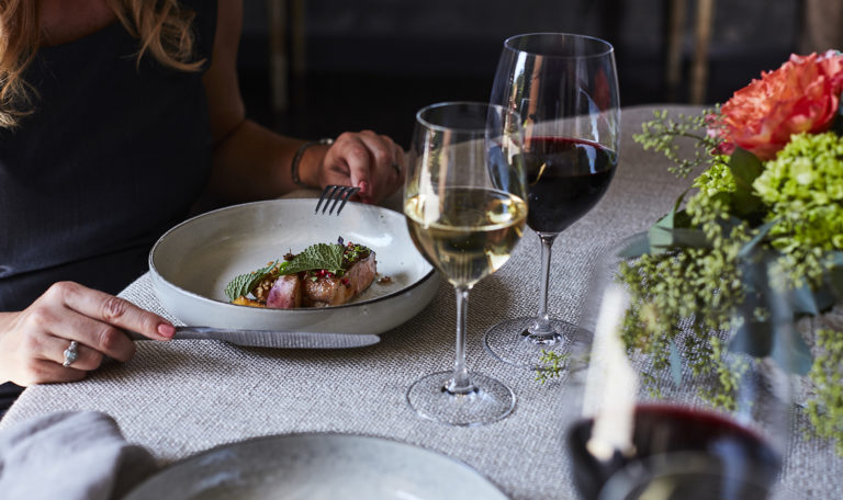 Person enjoying gourmet food paired with Jordan Cabernet Sauvignon and Jordan Chardonnay