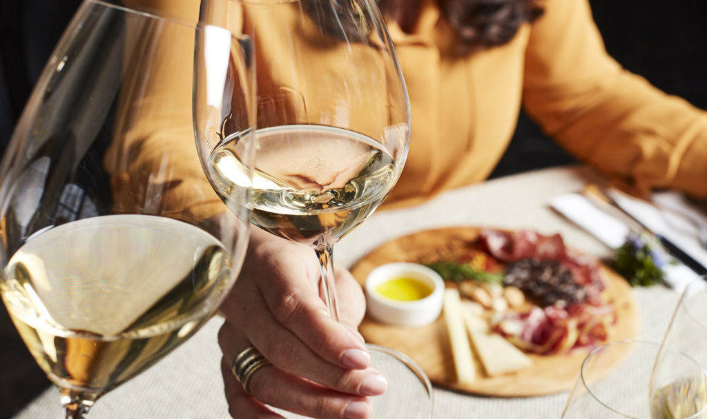 Person with glass of Jordan Chardonnay and food