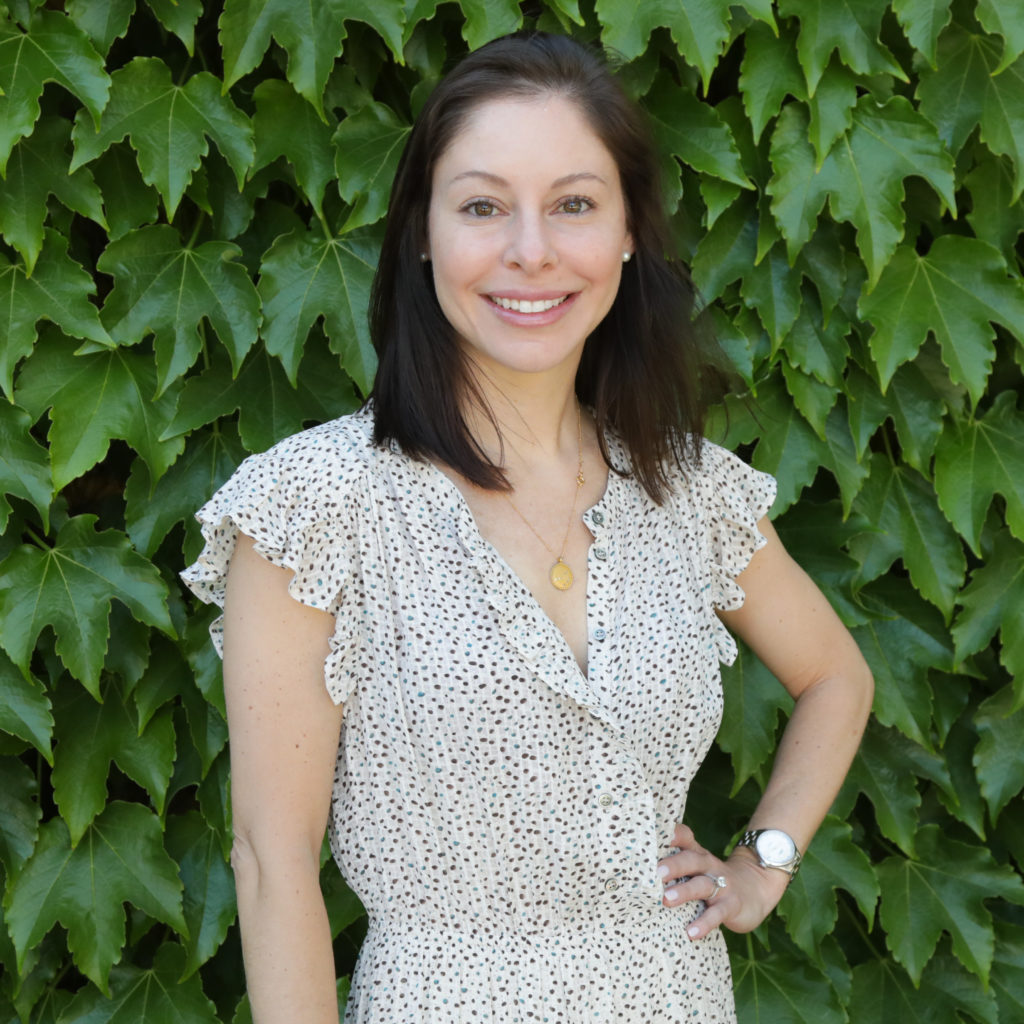 woman standing in front of green ivy wall