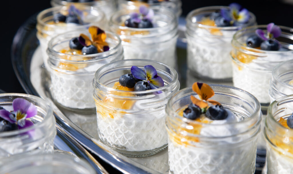 platter of jars filled with yogurt parfait and fruit