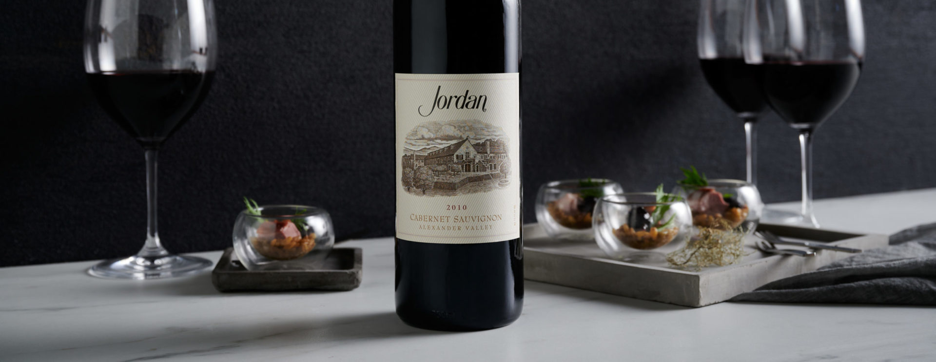 Bottle and glasses of Jordan Cabernet Sauvignon with food