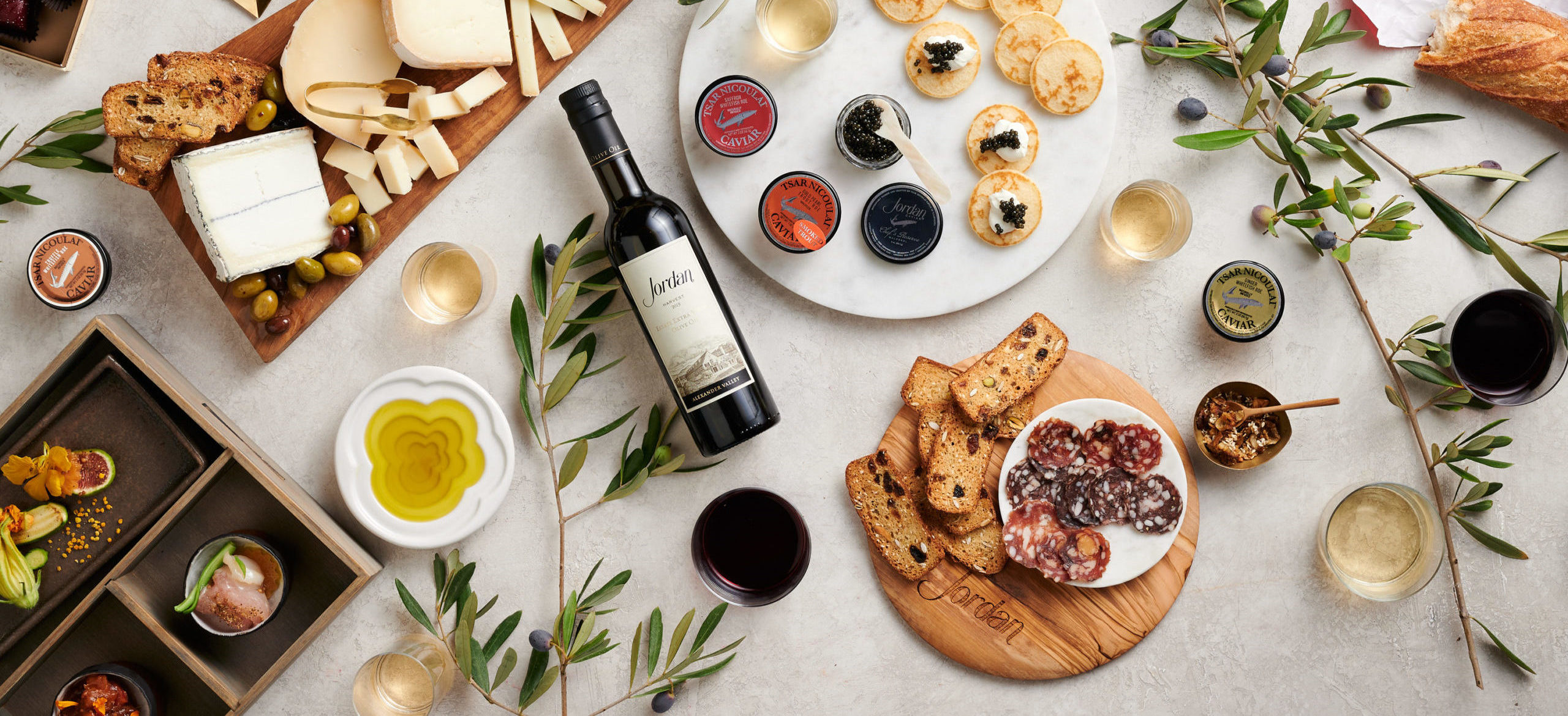 Jordan Olive Oil, Artisan Charcuterie Set and Chef’s Reserve Caviar on tabletop with olive branches