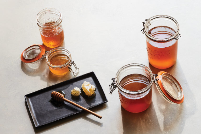 Honey in jars and honeycomb on a plate