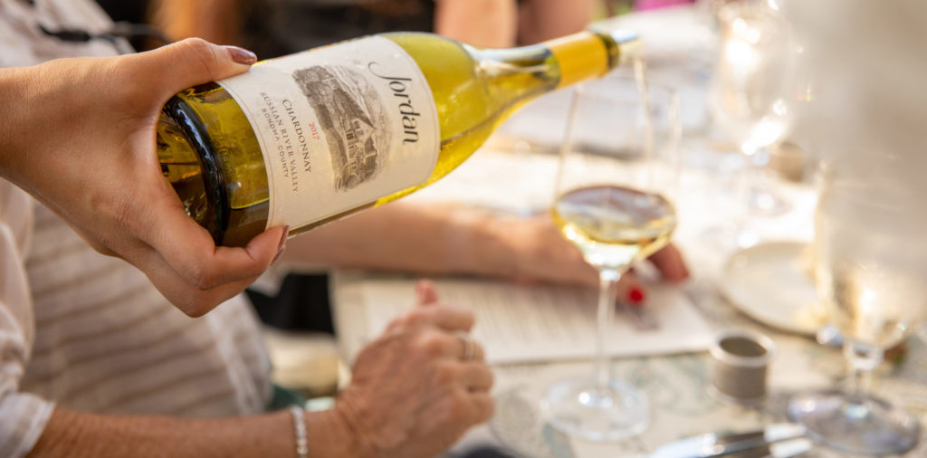 Person pouring Jordan Chardonnay wine into glass