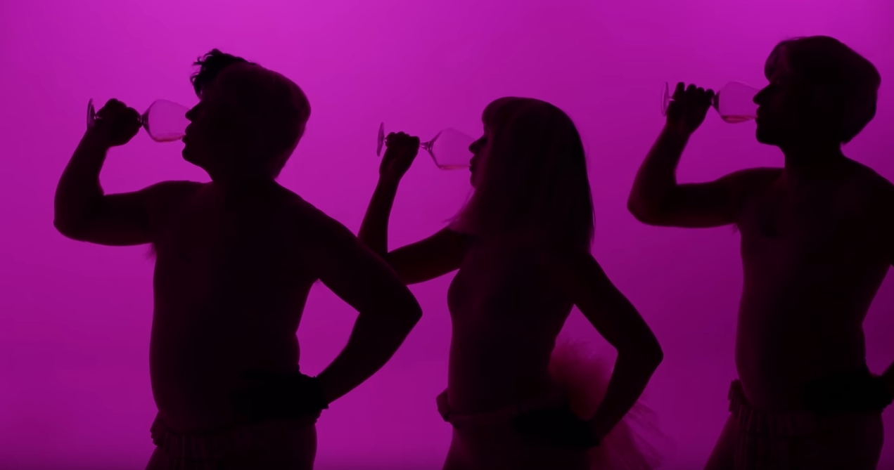 three silhouettes of people drinking wine with pink background