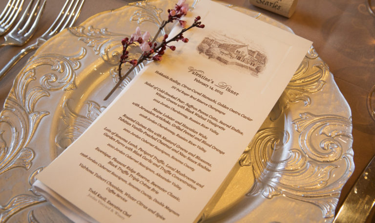 Aerial shot of Jordan Winery's 2015 Valentine's Day dinner menu on a decorative silver plate with a blossoming cherry branch.