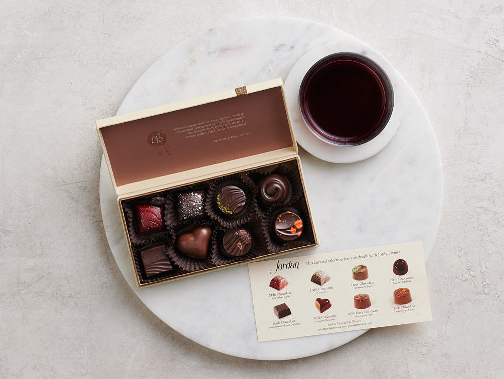 box of chocolates open with a glass of cabernet