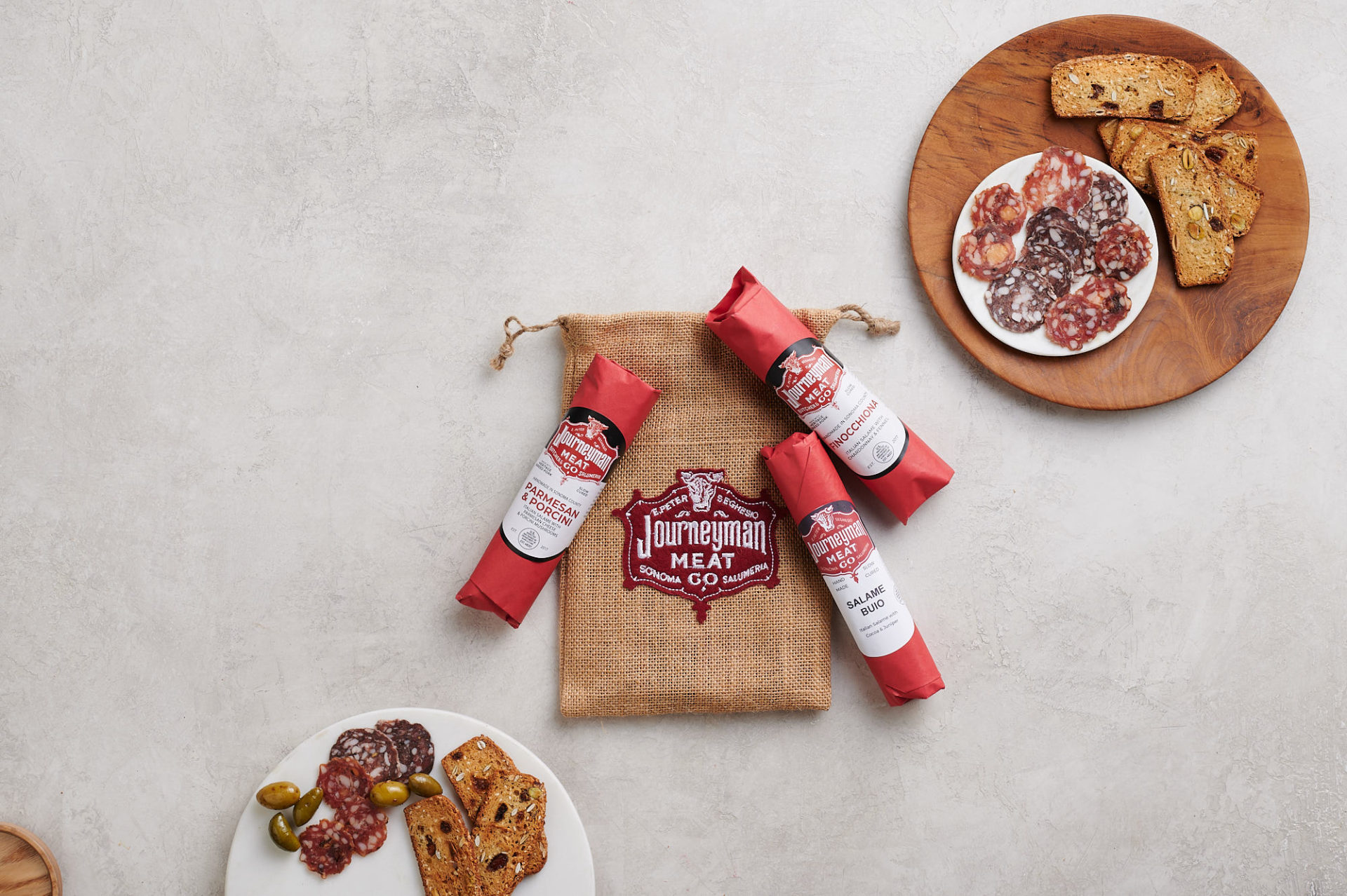 salumis and crostinis on wooden plate and table