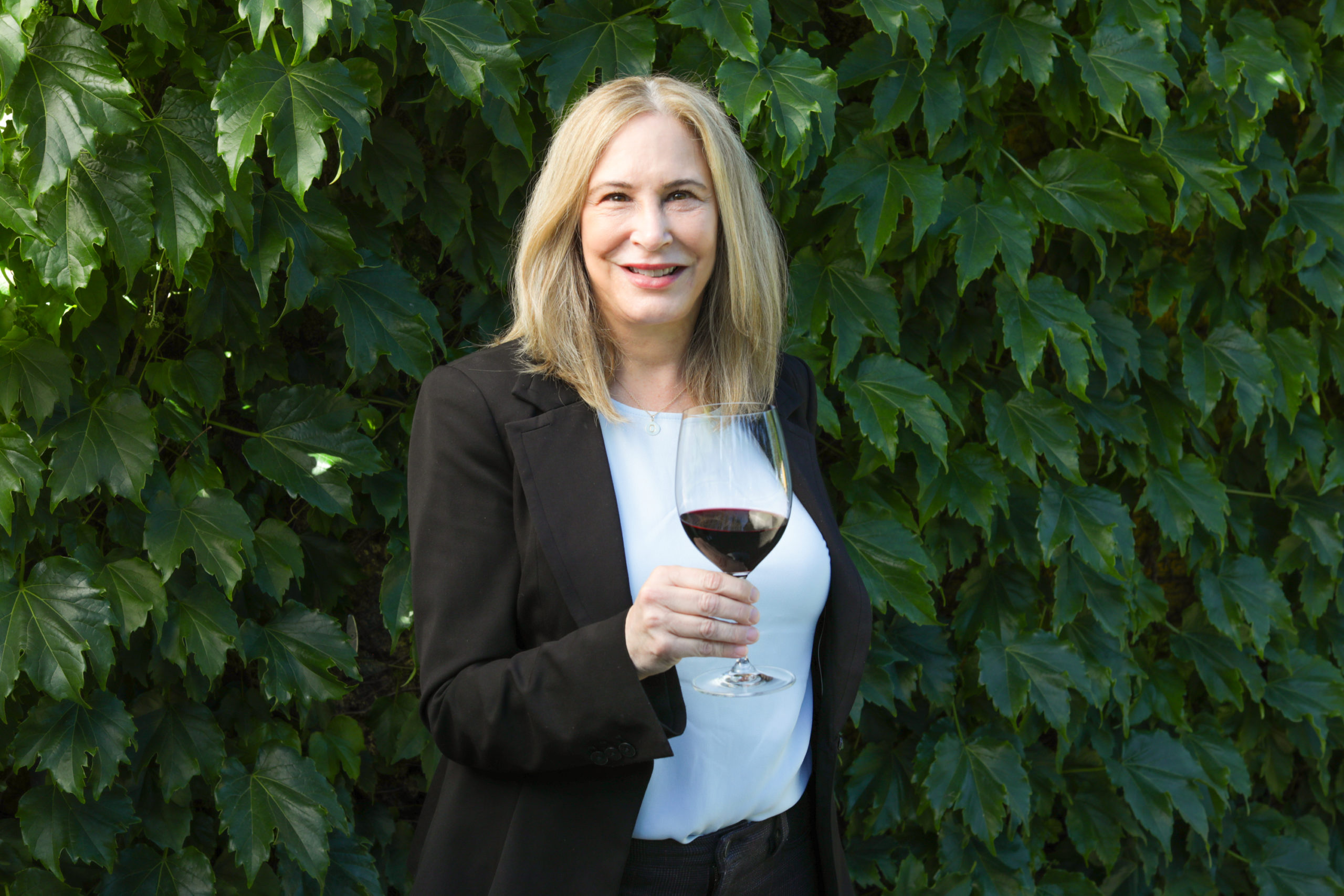 woman dressed in business attire with a glass of cabernet