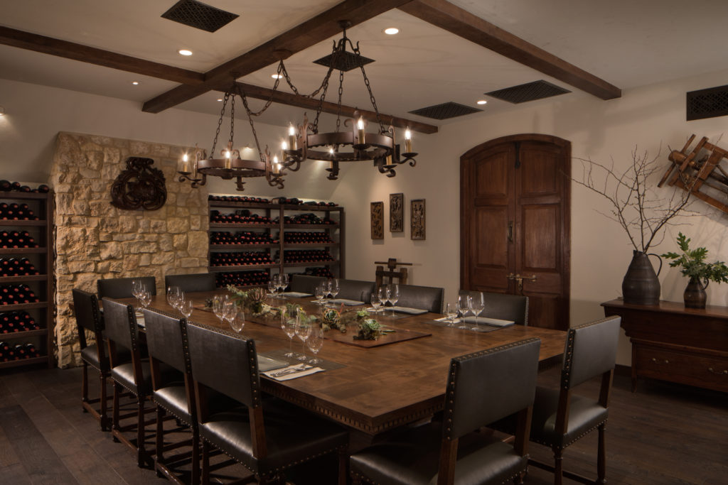 cellar room with large wooden table and chairs and wine wall