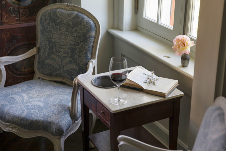 wine glass with open book and rose on a table