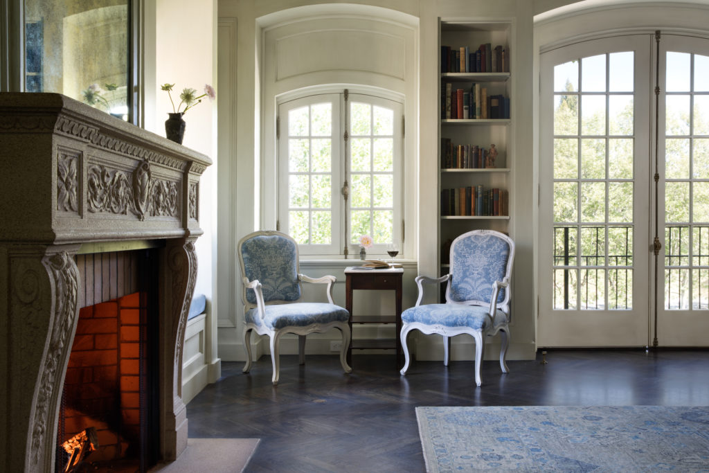 two chairs in library room with fireplace