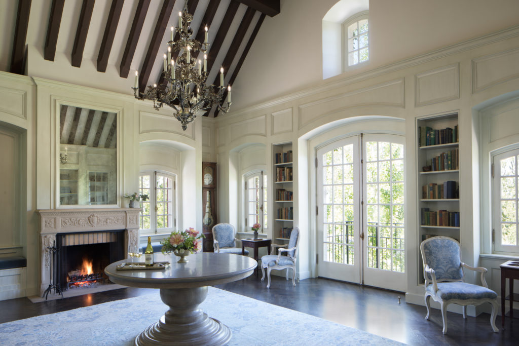 large room with chandelier, fireplace and bookshelves