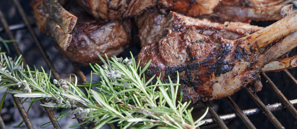 lamb chops placed on grill with rosemary